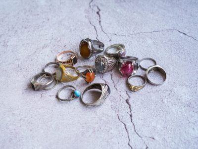 Vintage collection of man's old rings on the concrete background.